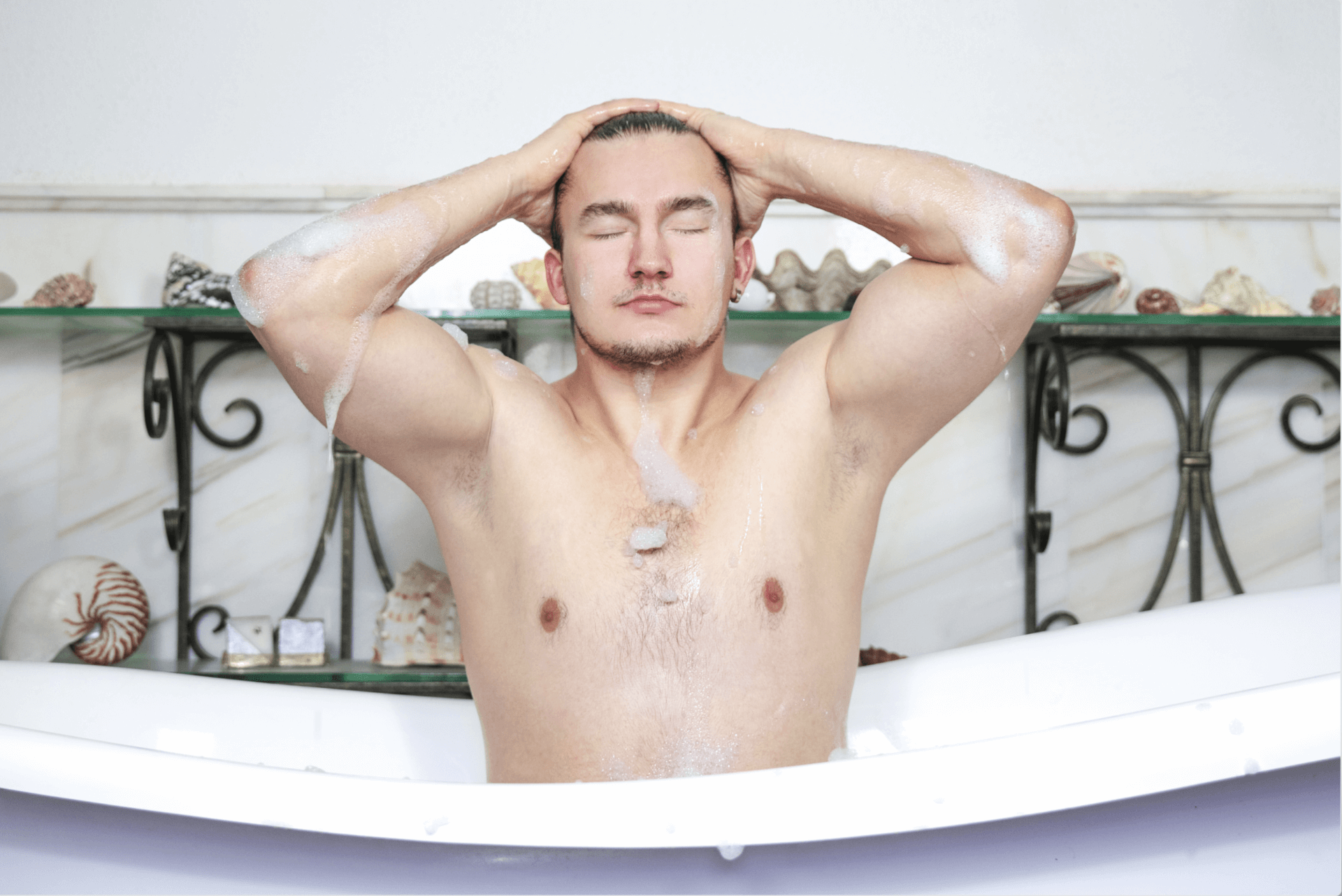 Man washing his hair while taking a bubble bath